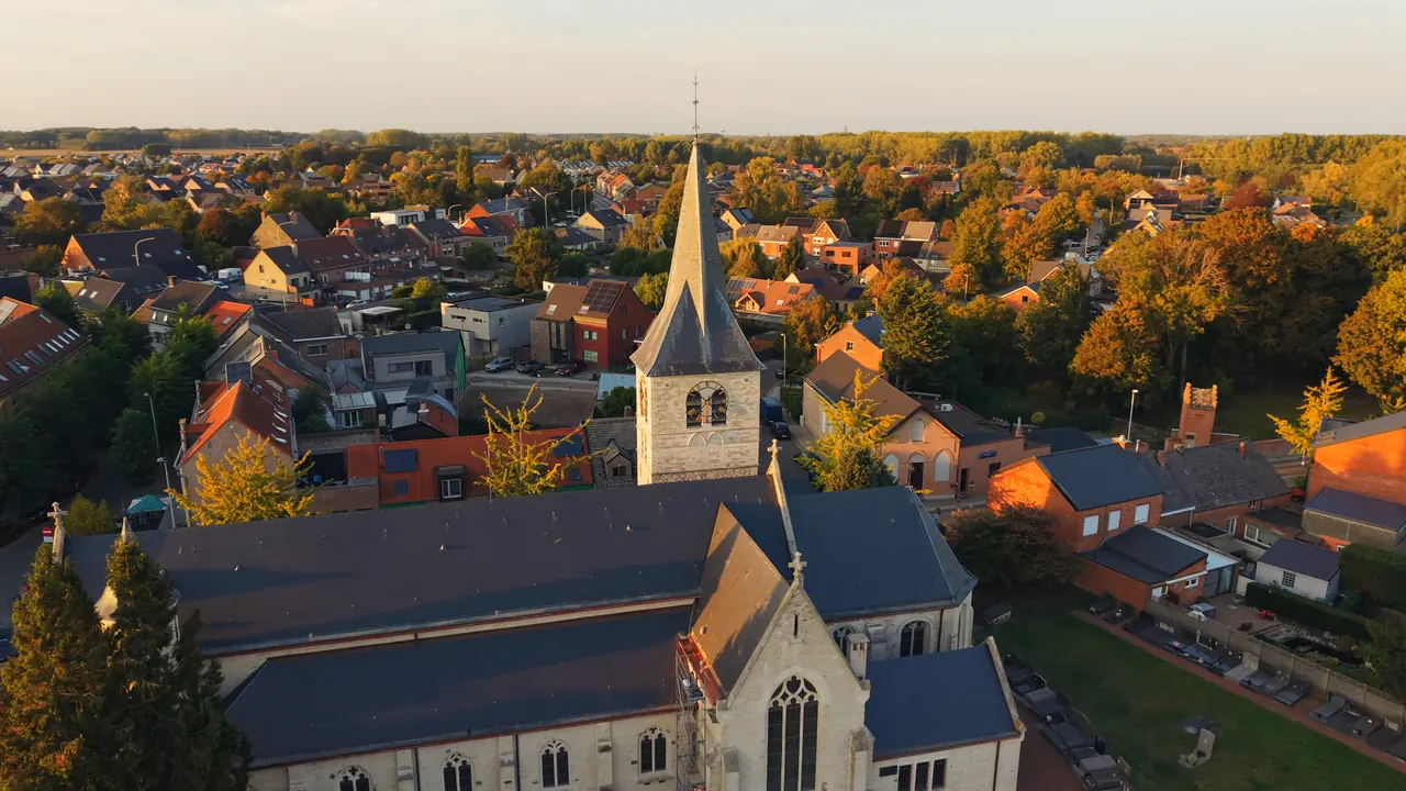 De Sint-Clemenskerk van Eppegem van opzij, toren en schip in het laatste zonlicht