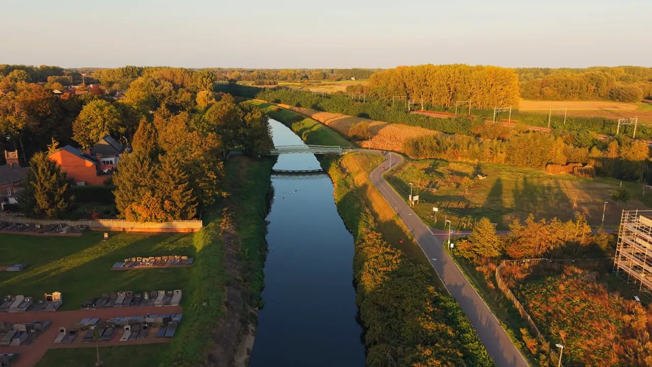 De Zenne in Eppegem met de voetbrug, de oevers in gouden avondlicht