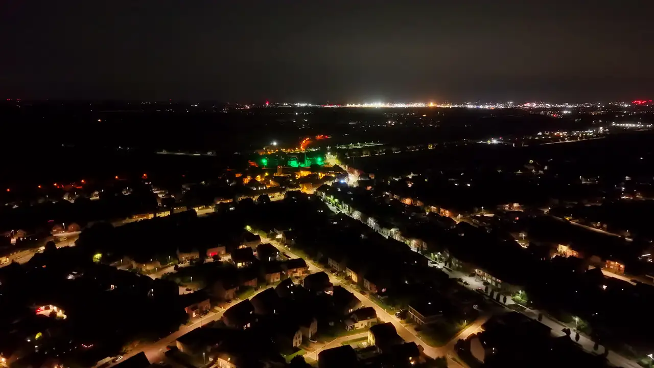 Een groen verlicht gebouw met de lichten tot aan de horizon
